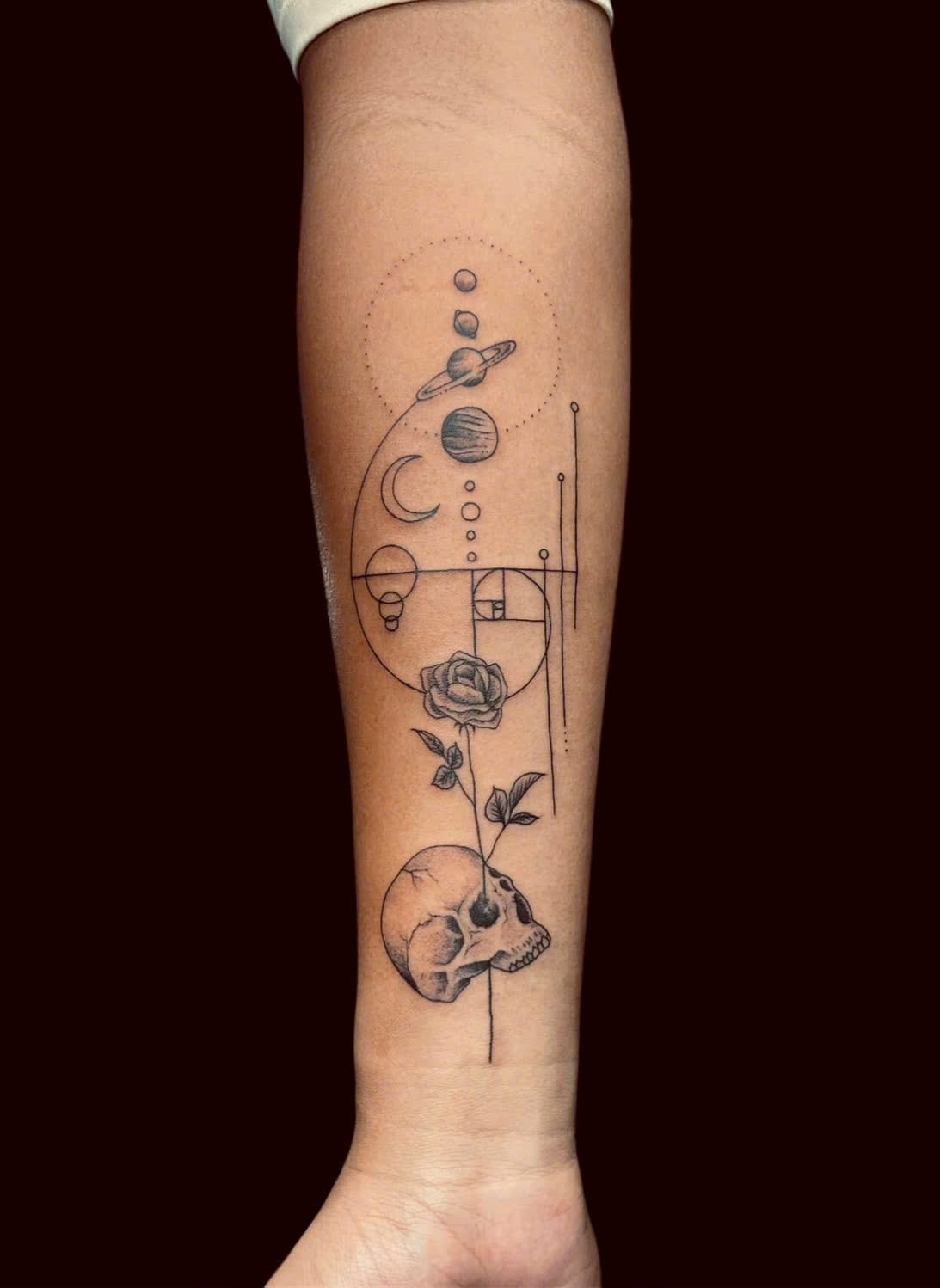 Geometric planets, golden ratio, rose and skull forearm tattoo — Rae Ink Saigon
